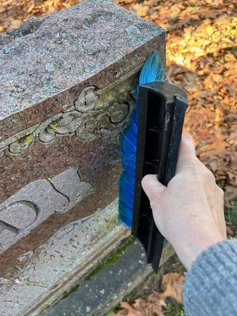 Brushing a granite monument to clean it