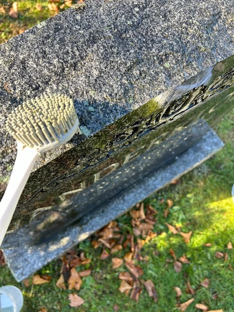 Brushing a granite monument clean